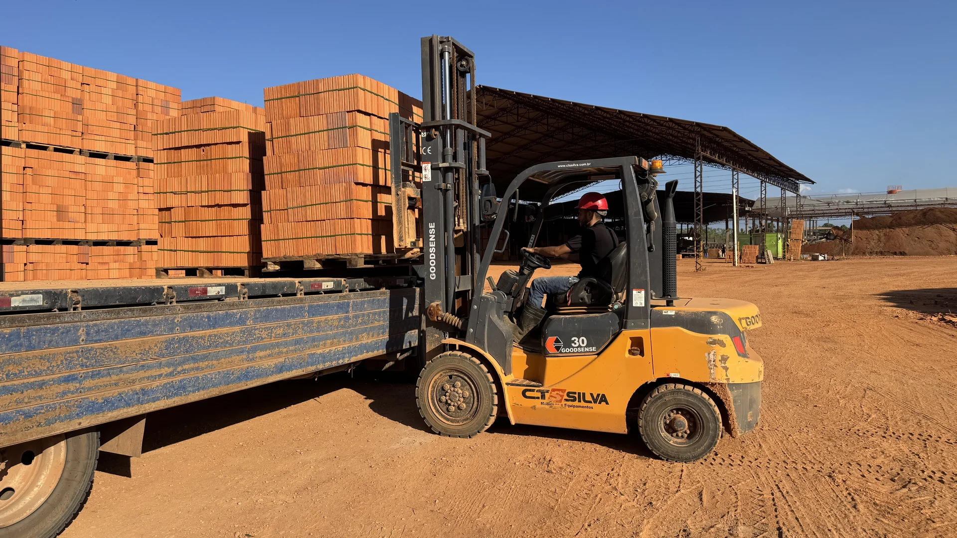 Empilhadeira carregando produtos cerâmicos em um caminhão na fábrica Amapá Telhas